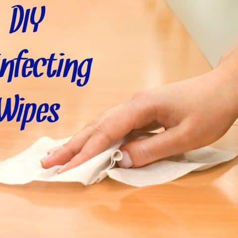 hand with DIY disinfecting wipes cleaning table