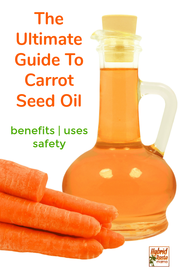 A bottle of carrot seed oil next to carrots