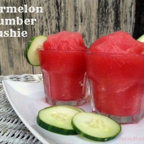 Two glass jars of watermelon cucumber slushies with a cucumber slice on the rim