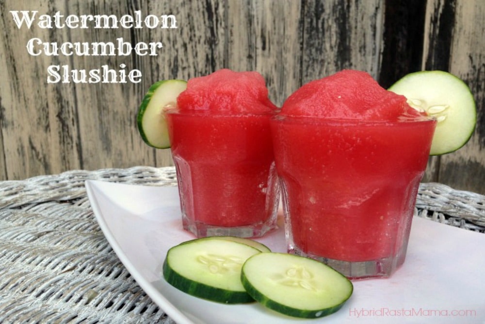 Two glass jars of watermelon cucumber slushies with a cucumber slice on the rim